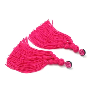 Gedetailleerd overzicht van handgemaakte roze kwastoorbellen in boho-stijl, kralen.