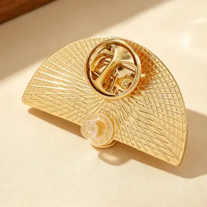 Detailed back view of a gold fan-shaped sliding brooch with a secure butterfly clutch
