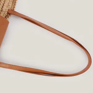 Detailaufnahme des braunen Lederriemens einer gewebten Papierschultertasche