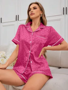 Dettaglio del set pigiama in raso rosa leopardato con profili e colletto a rever