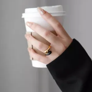 Anello aperto a goccia in oro 18k e smalto nero chic al dito