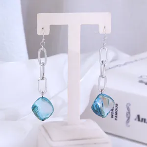 Detailopname van elegante lange oorbellen met blauwe schelp hanger voor dames en meisjes.