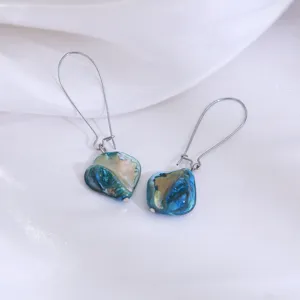 Gedetailleerde foto van vintage vakantie stijl natuurlijke blauwe schelp oorbellen.