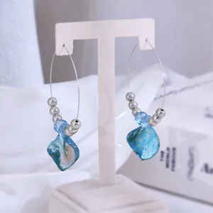 Gedetailleerd overzicht van vintage strandstijl oorbellen met blauwe steen en kralen.