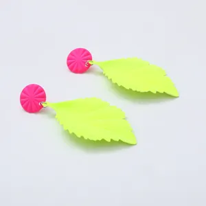 Fluorescerende groene oorbellen met roze ronde knopjes, opvallende geometrische mode sieraden.