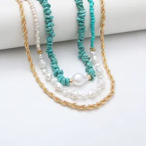 Close-up van bohemian meertalige turquoise parel halsketting met gouden kettingdetails.