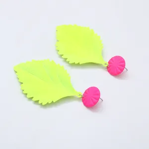 Neon groene blad oorknopjes met roze cirkelvormige accenten, trendy geometrische sieraden.