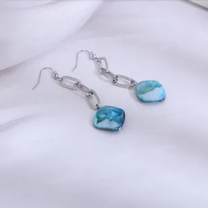 Gedetailleerd overzicht van deze lange zilveren ketting oorbellen met blauwe schelpen.