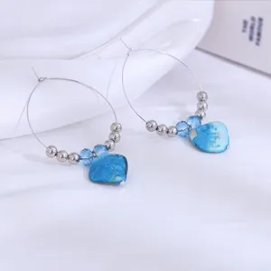 Detailopname van blauwe kralen creool oorbellen in strandstijl met prachtige turquoise stenen.