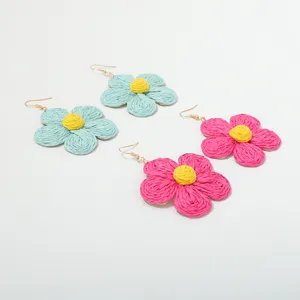 Handgemaakte raffia geweven bloemen oorbellen detail, bohemien stijl zomer sieraden.