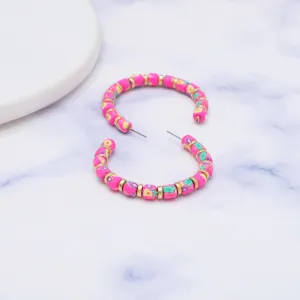 Gedetailleerd overzicht van handgemaakte polymeerklei kralen oorbellen met roze bloemen.