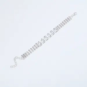 Zilveren strass armband detail met geometrische holle schakels en sprankelende stenen.