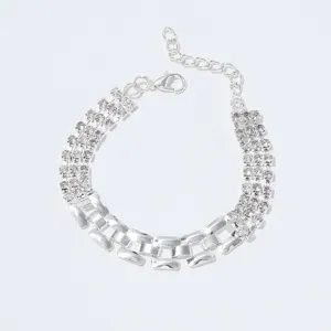 Gedetailleerde opname van een zilveren strass kettingarmband met verstelbare sluiting.