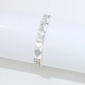Detailweergave van zilveren piramide armband met strass stenen en glanzend metaal.