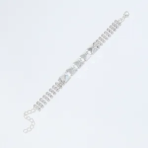 Gedetailleerde close-up van een zilveren strass armband met metalen klinknagels en kristallen.