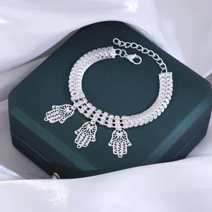Gedetailleerd overzicht van zilverkleurige hamsa hand armband met strass kettingdetails.