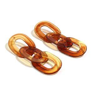 Gedetailleerd uitzicht van amberkleurige hars ketting oorbellen, retro acryl geometrische sieraden.