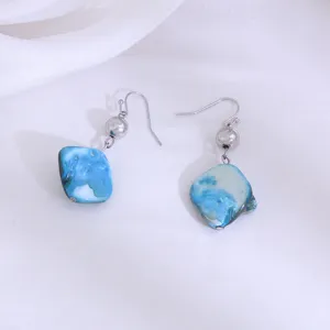 Gedetailleerd overzicht van modieuze pastorale blauwe schelp hangende oorbellen.