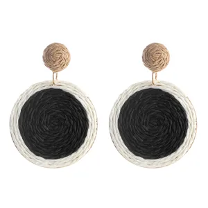 Gedetailleerd overzicht van handgeweven stro ronde boho oorbellen, stijlvol natuurlijk accessoire.