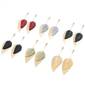Gedetailleerd shot van oorbellen met dubbele bladeren, minimalistische Morandi kleur sieraden.
