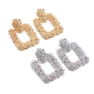 Chunky geometrische getextureerde oorknopjes in goud en zilver met een uniek onregelmatig mat patroon.