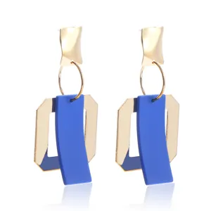 Gedetailleerd overzicht van geometrische holle metalen oorbellen in blauwe en gouden afwerking.