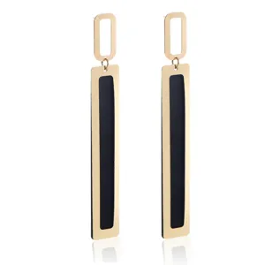 Gold and black geometric long drop earrings detail, elegant metal cutout design for women.