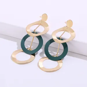 Minimalistische meerlaagse geometrische oorbellen in goud en donkergroen voor dames.