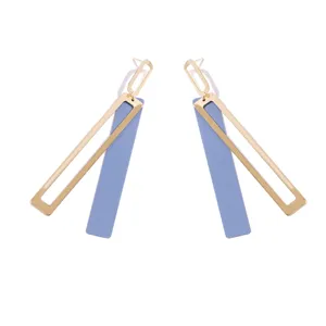 Close-up detail of geometric long drop earrings featuring a gold hollow frame and blue bar.