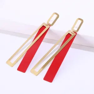 Close-up detail of stylish double-layer geometric long drop earrings in gold and red.
