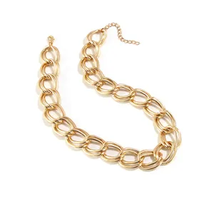 Dettaglio collana con catena d'oro spessa, maglie metalliche stile punk, bigiotteria.
