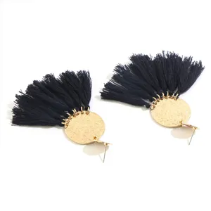 Black tassel earrings with gold-tone hammered disc detail, vintage bohemian long drop style.