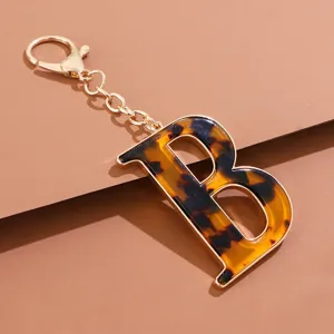 Nahaufnahme des Schildpatt-Buchstaben-B-Schlüsselanhängers mit goldener Hardware, elegantes Detail.