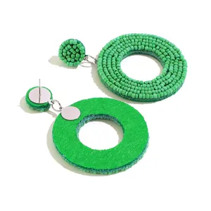 Handgemaakte groene kraal boho vintage cirkel oorbellen detail, hars kralen en metalen stekker.