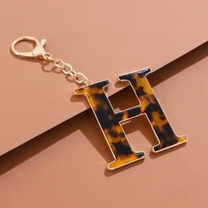 Detaillierte Nahaufnahme des stilvollen Schildpatt-Buchstaben-Schlüsselanhängers in Gold.