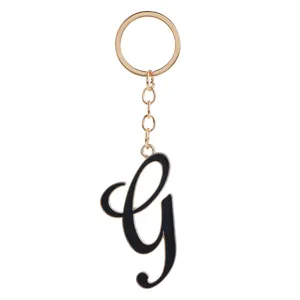 Gold-toned metal keychain featuring a sleek black enamel script letter G pendant detail.