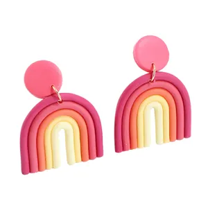Detail view of handmade polymer clay rainbow earrings featuring colorful arch and round stud design.