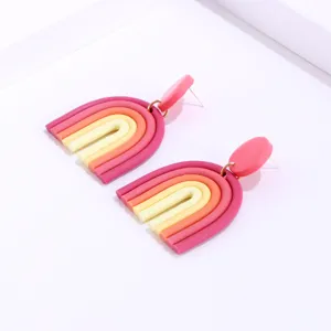 Polymer clay rainbow earrings detailed shot, colorful handmade bohemian style U-shaped jewelry.