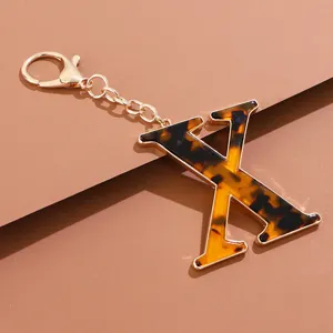 Schildpatt Acryl Buchstabe X Schlüsselanhänger Anhänger mit goldfarbener Metallkette und Kappe.