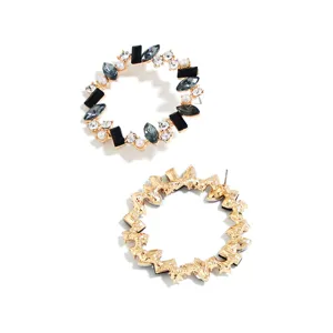 Detailed view of retro geometric gold hoop earrings inlaid with black and clear crystals.