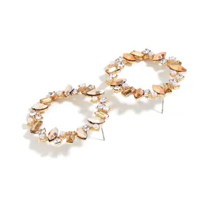 Detailed close-up view of gold circular rhinestone and pearl stud earrings for women.