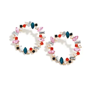 Close-up view of colorful rhinestone and pearl geometric round hoop earrings detail.
