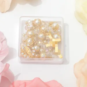 Gouden rozenkrans ketting met glasparels en kristal in een doorzichtige doos detail