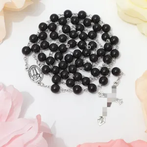Zwarte glasparels rozenkrans ketting met kruis hanger, religieuze sieraden detailweergave.