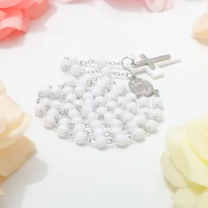 White bead rosary necklace featuring a silver cross pendant and prayer beads for women.