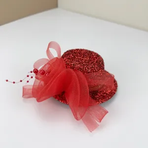 Red mini top hat hair clip detail showing sparkly glitter texture and mesh tulle bow decoration.