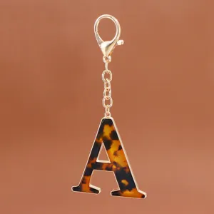 Nahaufnahme des stilvollen Schildpatt Buchstabe A Schlüsselanhängers mit goldener Hardware.