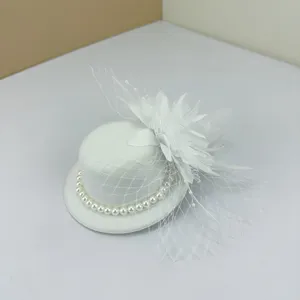 Detail of elegant white vintage mini top hat hair clip with pearls, mesh veil, and floral accent.
