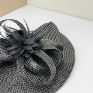 Dettaglio elegante di fascinator nero, accessorio per capelli fatto a mano con piume e fiori.