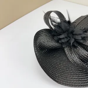Vista dettagliata del cappello fascinator nero, elegante ornamento in piuma e fiore per matrimonio.